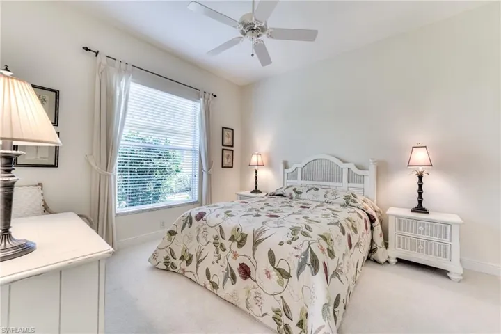 Bedroom featuring ceiling fan, light colored carpet, and large window
