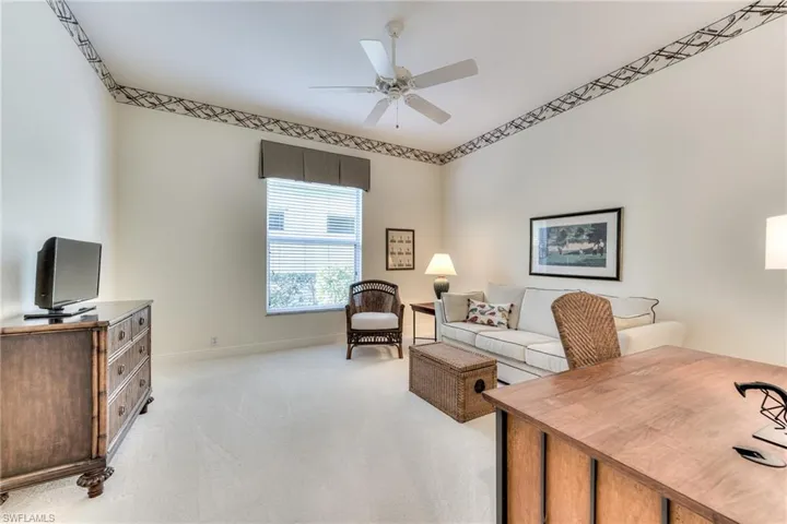 Large carpeted den with ceiling fan