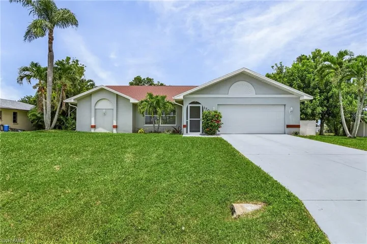Single story home featuring a garage and a front yard