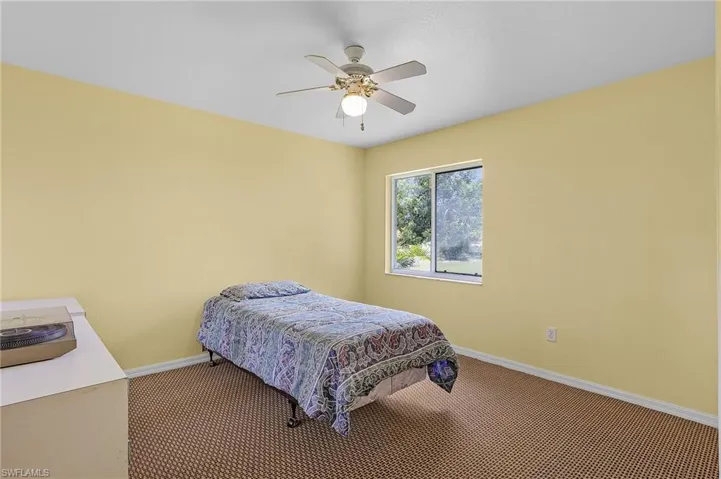Carpeted bedroom with ceiling fan