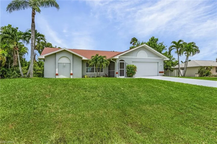 Ranch-style house with a garage and a front lawn