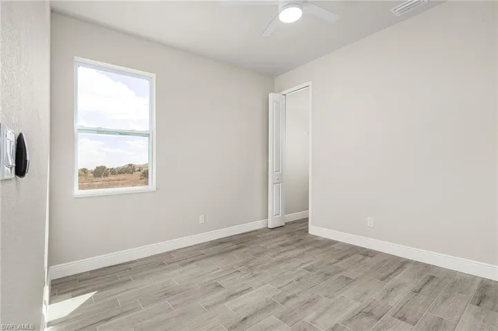 Unfurnished room with ceiling fan and light wood-type flooring