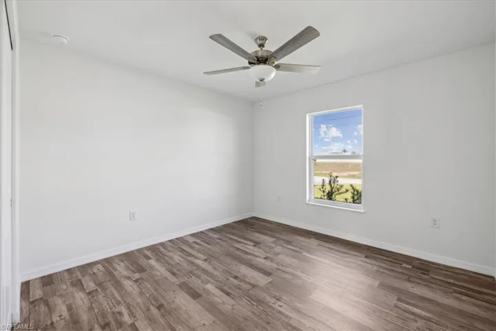 Empty room with ceiling fan and wood-type flooring