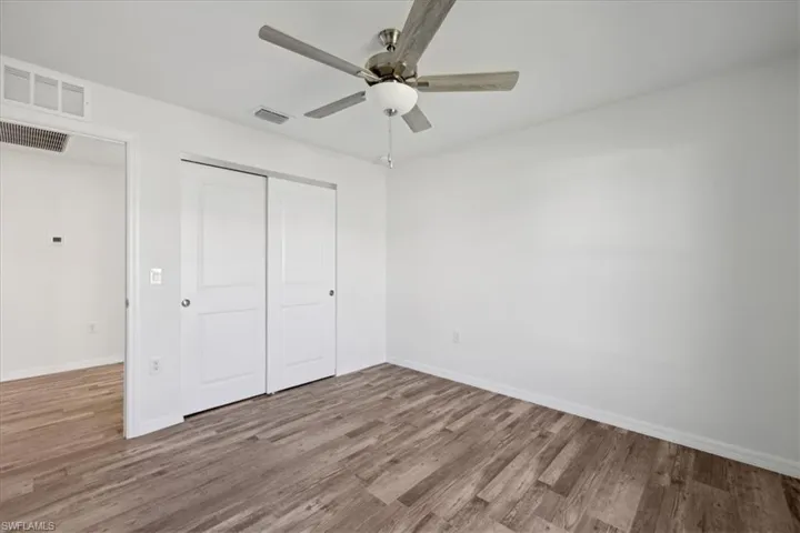 Unfurnished bedroom with ceiling fan, a closet, and hardwood / wood-style flooring