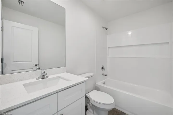 Full bathroom with toilet, bathing tub / shower combination, and vanity