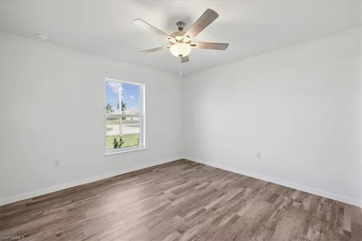 Empty room with wood-type flooring and ceiling fan