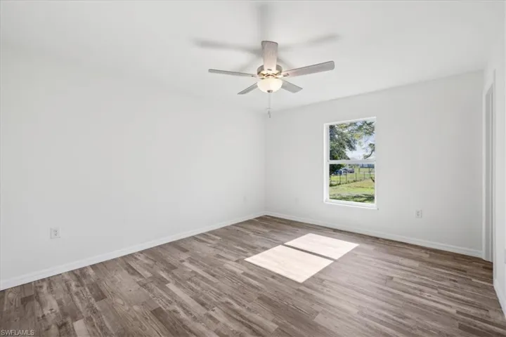 Unfurnished room featuring ceiling fan and wood-type flooring