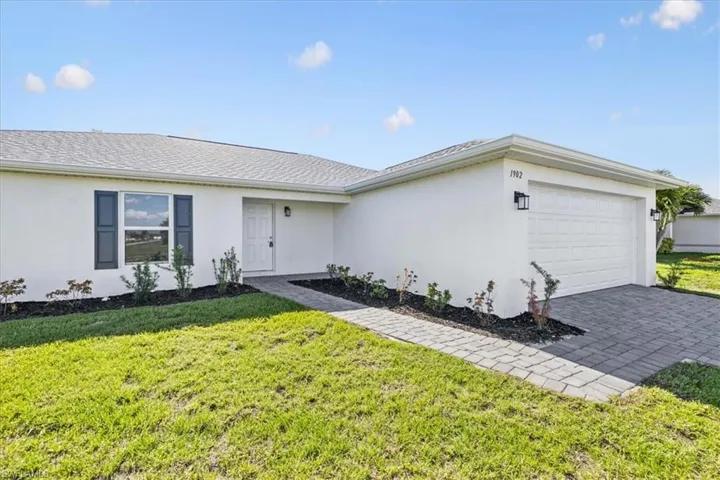 Ranch-style house with a garage and a front yard