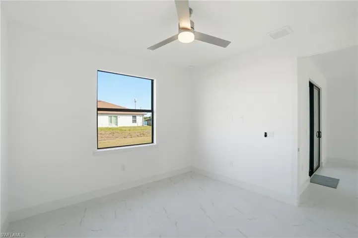 Unfurnished room with light marble finish flooring and ceiling fan