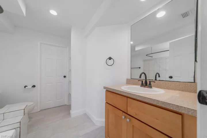 Primary Bathroom, door to garage, needs some updating
