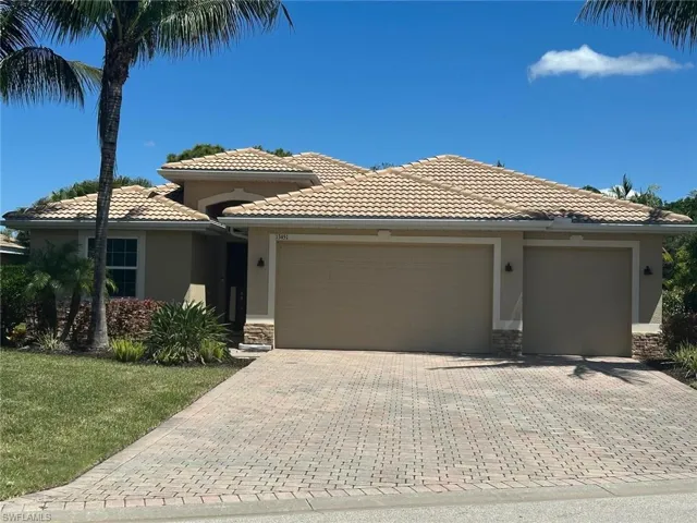 Mediterranean-style stucco exterior featuring a tile roof and stone accents