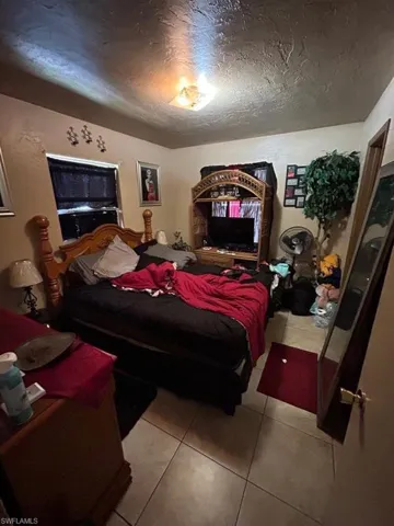 Tiled bedroom with a textured ceiling