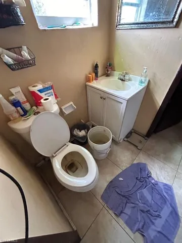 Bathroom with vanity, toilet, and tile floors