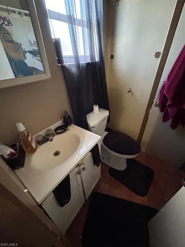 Bathroom featuring tile floors, vanity, and toilet