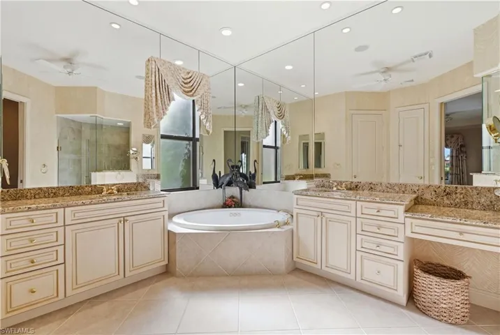 A spacious primary bathroom with two separate vanity areas.