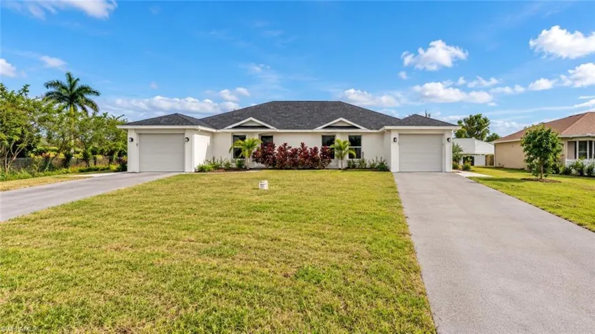 Contemporary duplex featuring a dark shingle roof, white stucco exterior, two single-car garages, and separate paved driveways