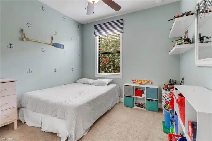 Bedroom with light carpet and a ceiling fan