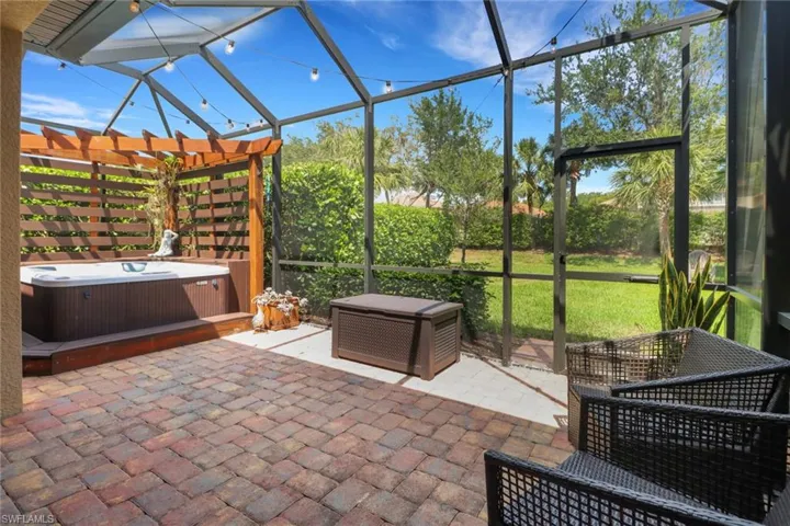 View of patio / terrace featuring a hot tub, a lanai, and a pergola
