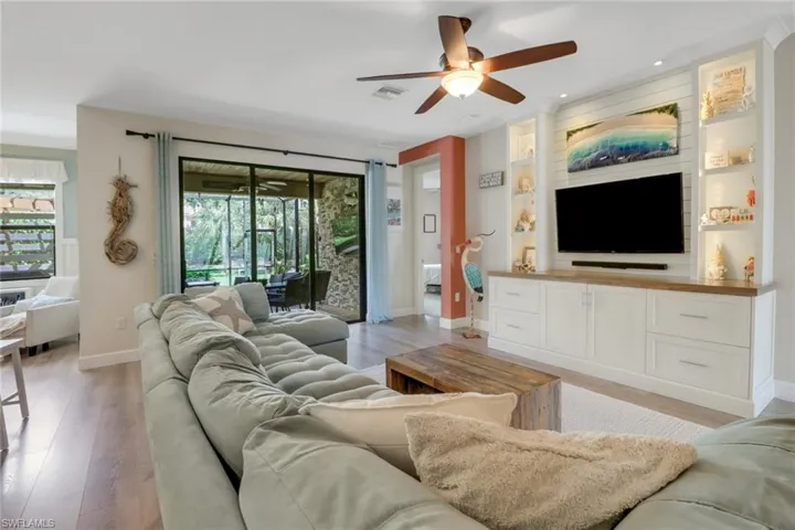 Living room featuring visible vents, built in features, baseboards, ceiling fan, and light wood finished floors