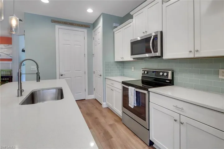 Kitchen with light wood-type flooring, light countertops, recessed lighting, a sink, and stainless steel appliances