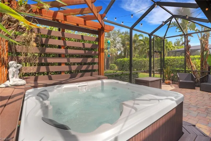 View of patio / terrace with glass enclosure and a hot tub