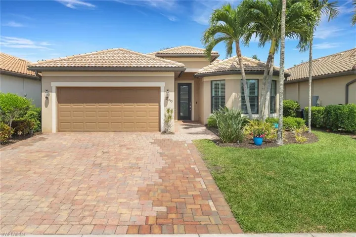 View of front of house featuring a garage, a front lawn, decorative driveway, stucco siding, and a tile roof