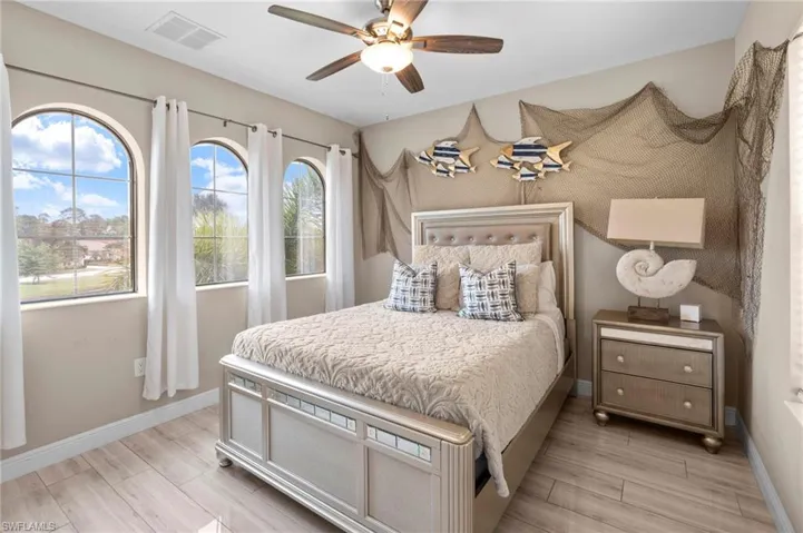 Bedroom with wood tiled floors and a ceiling fan