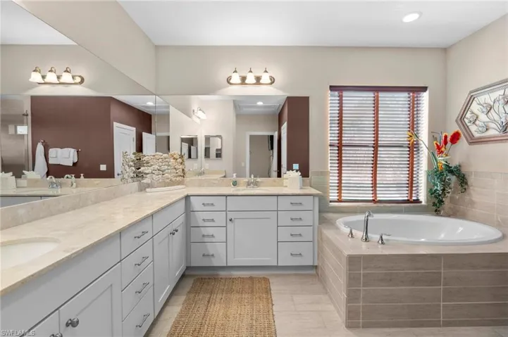 Full bath with a bath, double vanity, and recessed lighting