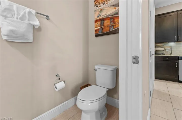 Bathroom with decorative backsplash, light tile patterned floors, and ornamental molding