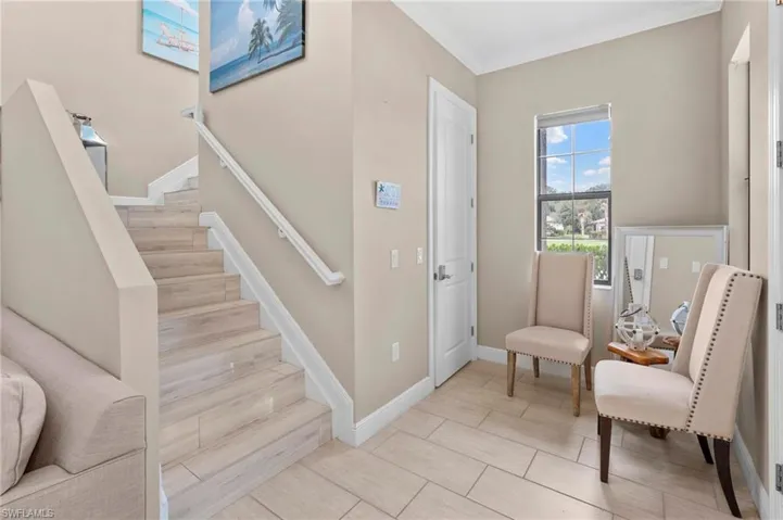 Living area featuring stairs, crown molding, and wood tiled floors