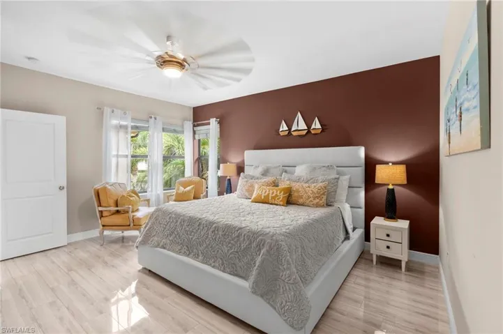 Primary Bedroom with light wood-style floors and a ceiling fan
