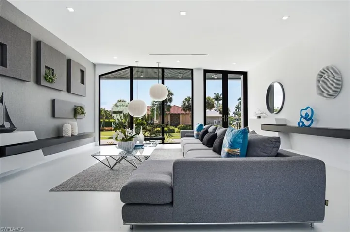 Expansive living area with large format flooring, recessed lighting, and floor-to-ceiling windows