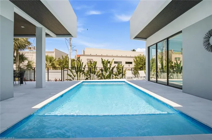 Rectangular pool with light blue tiling and white coping