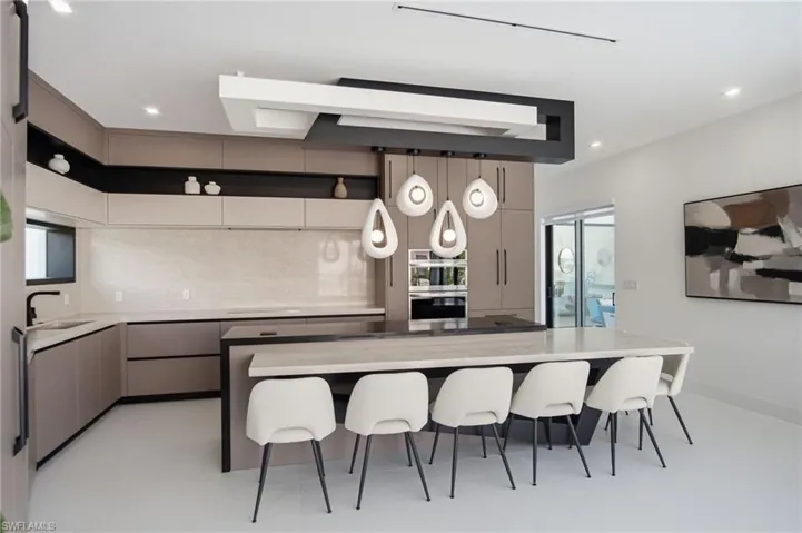 Contemporary kitchen featuring an expansive central island with seating