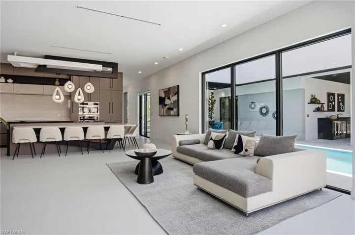 Open-concept living space with light-toned flooring and contemporary recessed lighting