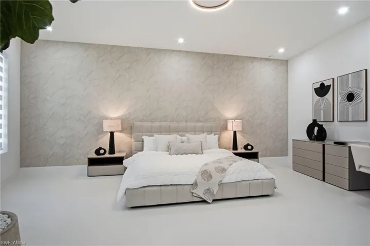 Spacious room featuring a textured accent wall, recessed lighting, and light-toned flooring