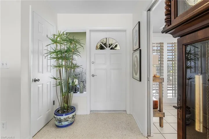 View of entrance foyer with storage closet and pocket door to kitchen