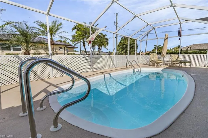 View of swimming pool with a patio and glass enclosure