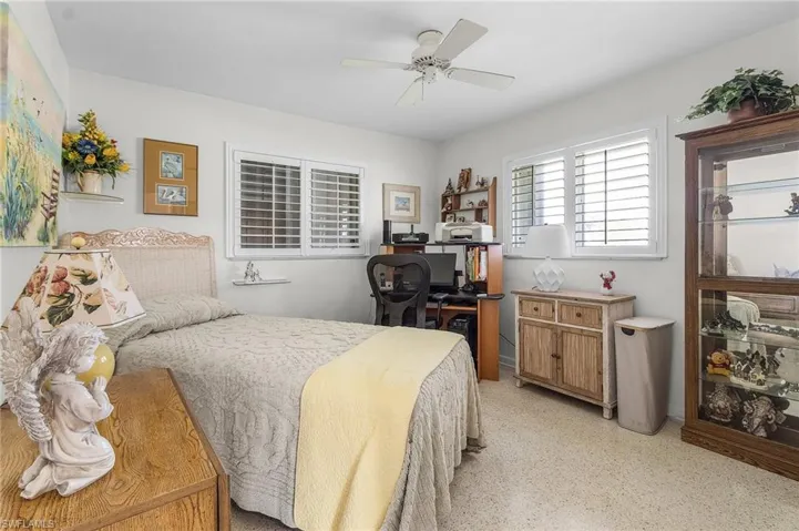 Bedroom number 3 with ceiling fan, terrazo floors, newer windows and plantation shutters