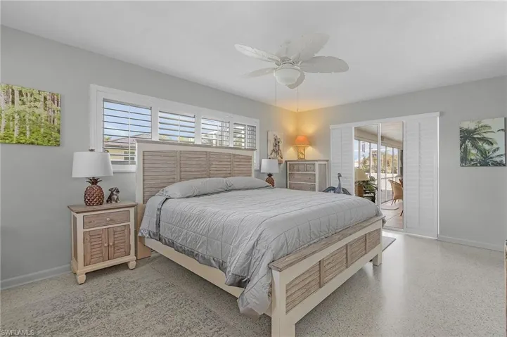 Bedroom featuring ceiling fan. plantation shutters on windows and slider to the Florida room