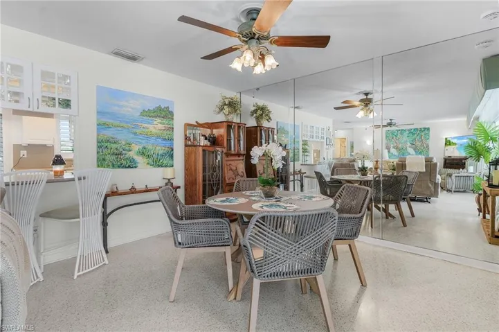 Dining space with ceiling fan, terrazo floors and breakfast bar open to kitchen