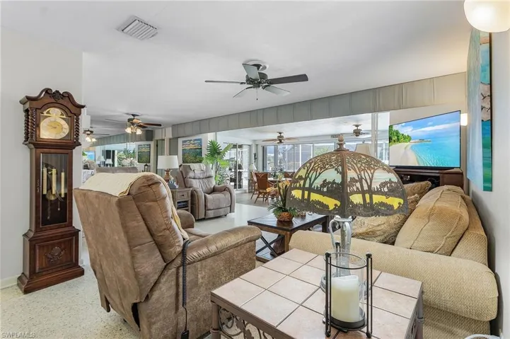 View of living room with pocket sliders to the enclosed Florida room and pool