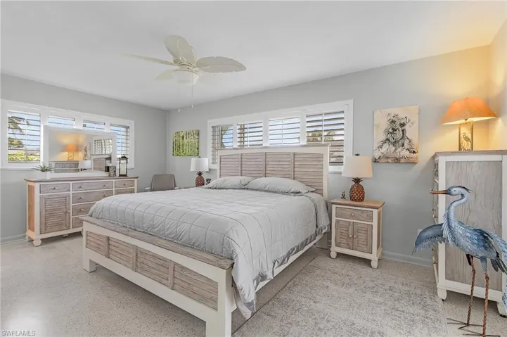 Primary Bedroom with ceiling fan. terrazo floors, plantation shutters, walkin closet and insuite bath. This bedroom is located on the NW corner of home