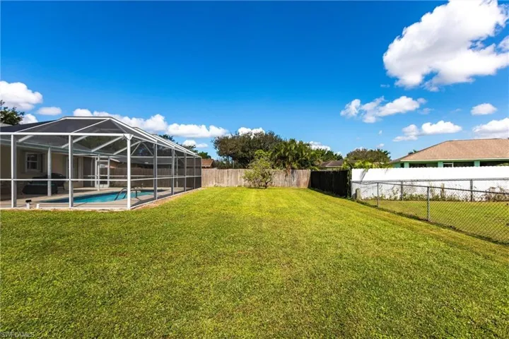 View of yard featuring a fenced in pool and glass enclosure
