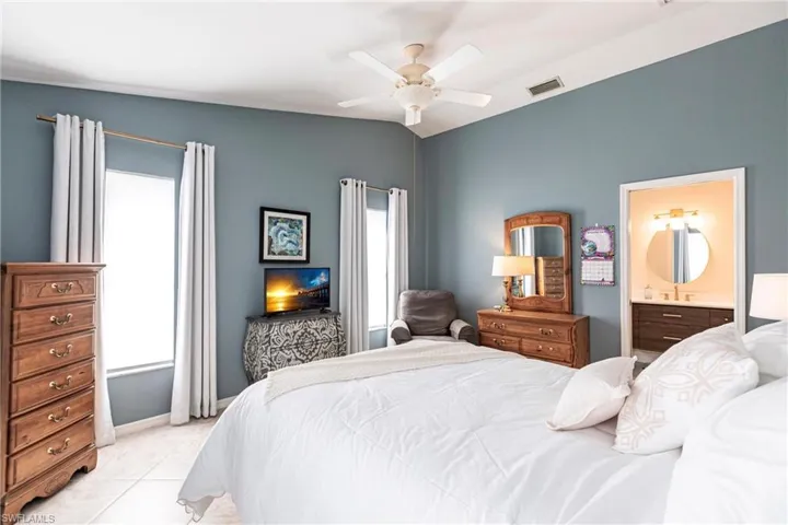 TiledPrimary  bedroom with ensuite bath and ceiling fan