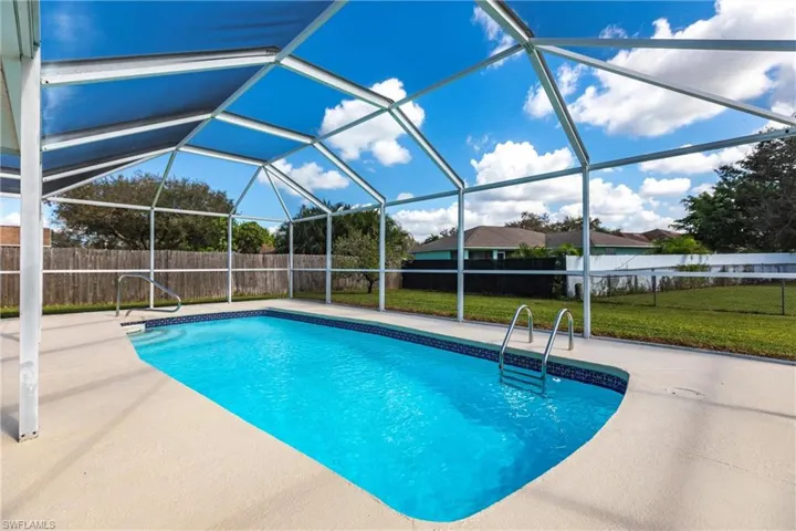 View of pool with a lanai area, a lawn, and a lanai