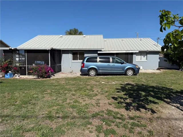 The property features a screened-in patio and a light-colored metal roof