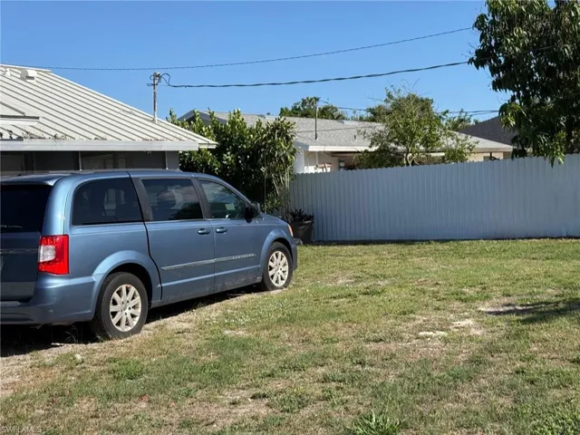 The property features a private yard area with a fence, and a portion of a building with a metal roof