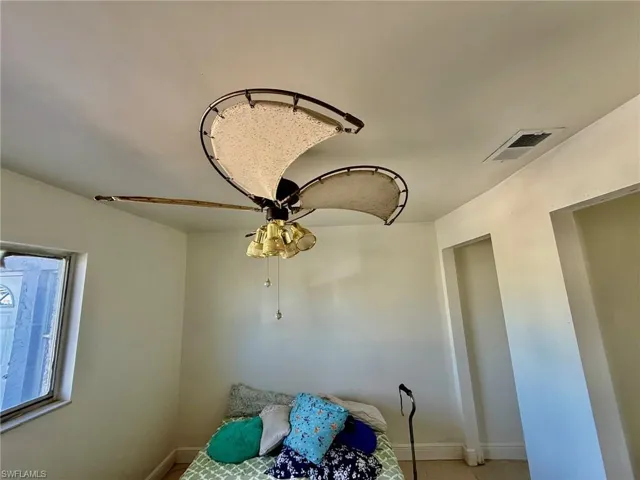 This room features a ceiling fan with integrated lighting, a window, and recessed wall spaces