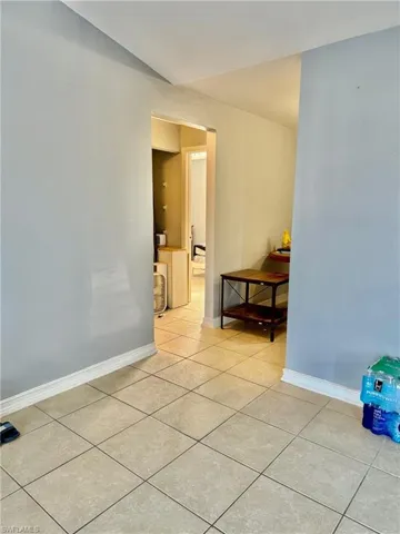 The property features light-toned tiled flooring throughout, complemented by light blue walls and white baseboards